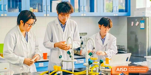 Students in lab coats working on a science experiment together at Yew Chung International School of Shanghai.