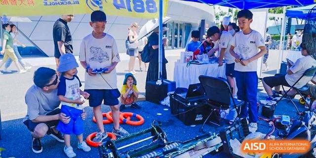 Students at an outdoor event booth with various hands-on activities at Yew Chung International School of Shanghai.