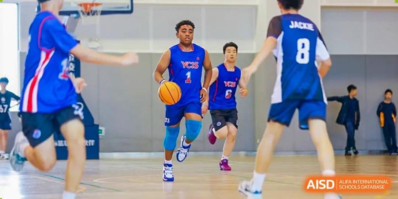 A male student dribbling a basketball down the court at Yew Chung International School of Shanghai.