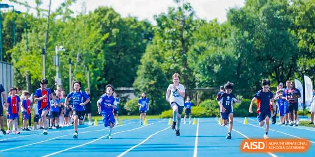 Students running a race on a blue track at Yew Chung International School of Shanghai.
