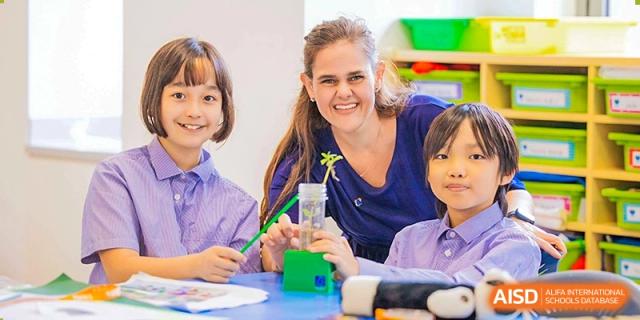 A teacher assisting students with a hands-on activity at Yew Wah International Education School of Shanghai Lingang.