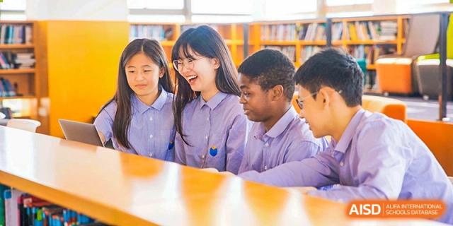 Students smiling and learning in a classroom at Yew Wah International Education School of Shanghai Lingang.