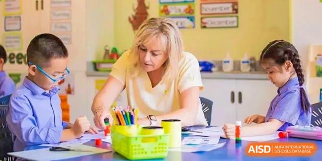 A teacher working with art supplies and students at Yew Wah International Education School of Shanghai Lingang.