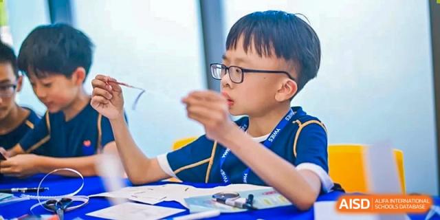 A focused student wearing glasses and participating in a class at Yew Wah International Education School of Shanghai Lingang.