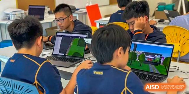 Students using laptops for a project in a classroom at Yew Wah International Education School of Shanghai Lingang.