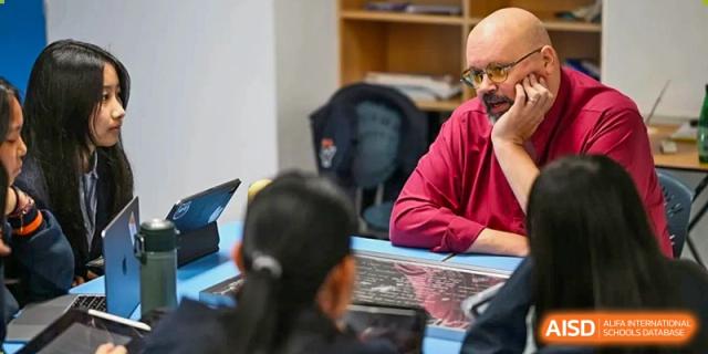 A teacher talking to a student in a classroom at Yew Wah International Education School of Shanghai Lingang.