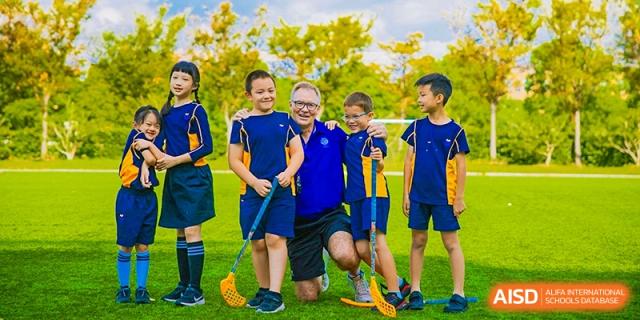 Students and a teacher playing floorball at Yew Wah International Education School of Shanghai Lingang.