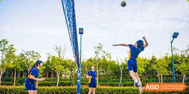 Students playing volleyball on the school campus at Yew Wah International Education School of Shanghai Lingang.