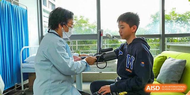 A student getting a blood pressure check from a school nurse at Yew Wah International Education School of Shanghai Lingang.