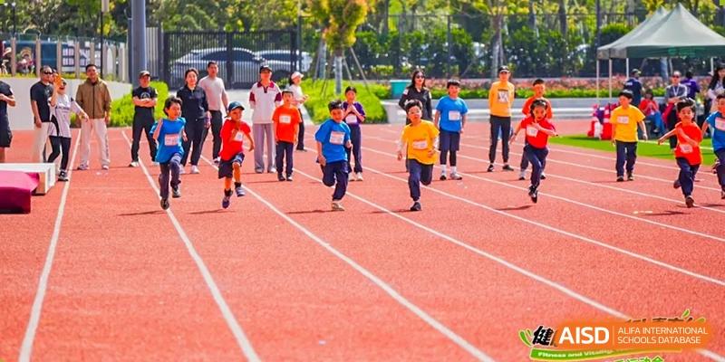 Students from Dingwen Academy Hangzhou competing in a running race on an outdoor track.