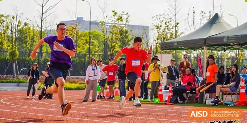 A student from Dingwen Academy Hangzhou running in a sprint event on a track during a sports day competition.