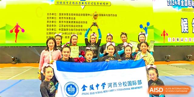 Group of students from International Department of Jinling High School Hexi Campus holding a championship trophy and a banner after a sports competition.