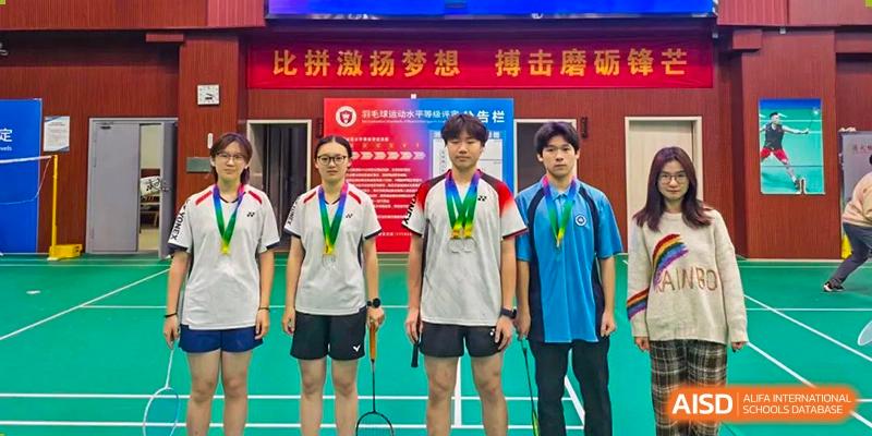 Three students from International Department of Jinling High School Hexi Campus standing on a podium or stage wearing medals after a competition.