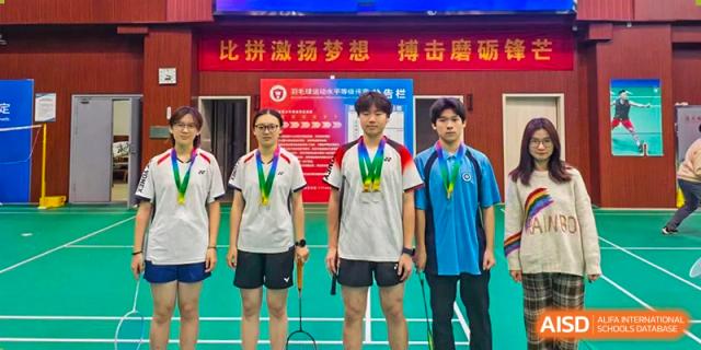 Three students from International Department of Jinling High School Hexi Campus standing on a podium or stage wearing medals after a competition.
