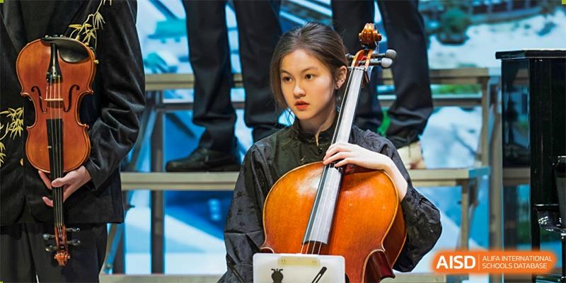 A female student from International Department of Jinling High School Hexi Campus playing the cello during a performance or event.