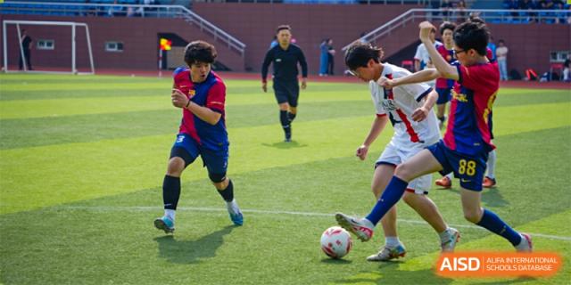A dynamic shot of students from International Department of Jinling High School Hexi Campus competing in a soccer match on a field.