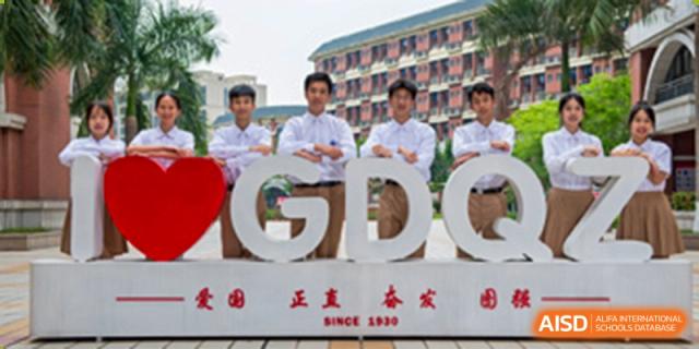 Students from the Guangdong Overseas Chinese High School International Curriculum posing with a large GDO sign, likely for the school's name.