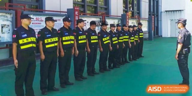 A line of security or student patrol personnel in uniform at Wuhan Weiming Senior High School standing on a green surface.