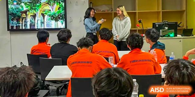 Close-up of the backs of several Wuhan Weiming Senior High School students in orange uniforms, paying attention in class.