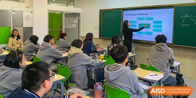 Wuhan Weiming Senior High School students sitting in a classroom focused on a teacher or presentation screen.