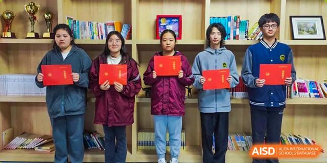 Three female Wuhan Weiming Senior High School students posing with award certificates after a competition or ceremony.