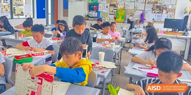 Young students focused on a project at their desks in a classroom at the Shanghai Jincai High School International Division.