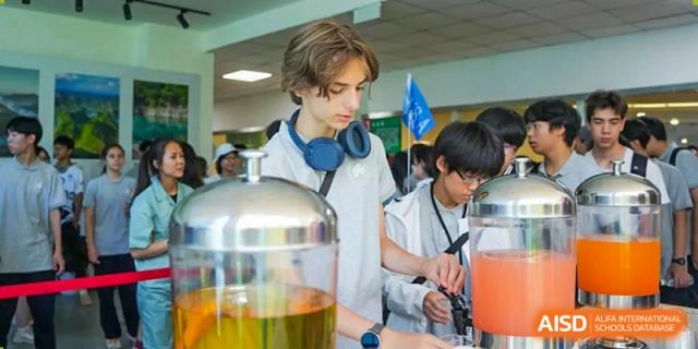 A male student in a lab coat using a microscope in a science lab at the Shanghai Jincai High School International Division.