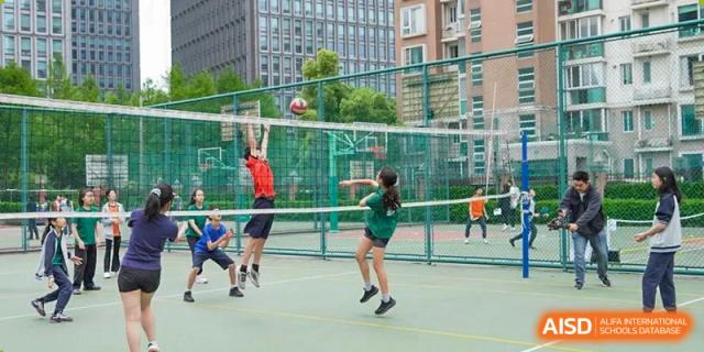 Students playing volleyball on an outdoor court at the Shanghai Jincai High School International Division.