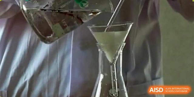 A close-up shot showing a chemistry experiment in progress, with a light-colored substance being poured through a funnel. Canada British Colombia International Schools-Hefei.