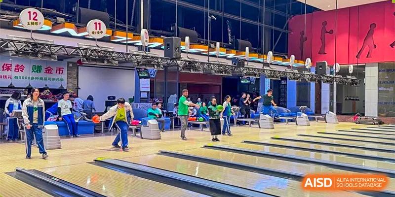 A group of students and instructors bowling and socializing at an indoor alley as an extracurricular activity. Canada British Colombia International Schools-Hefei.