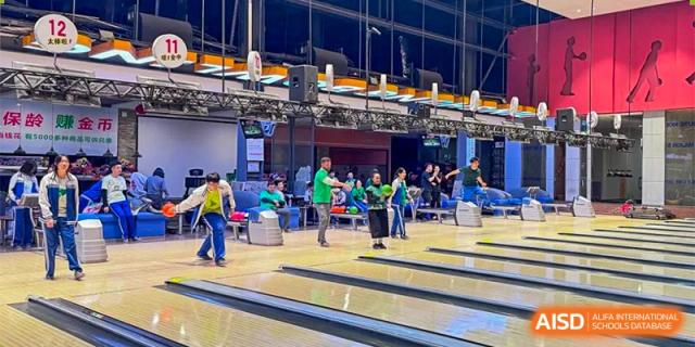 A group of students and instructors bowling and socializing at an indoor alley as an extracurricular activity. Canada British Colombia International Schools-Hefei.