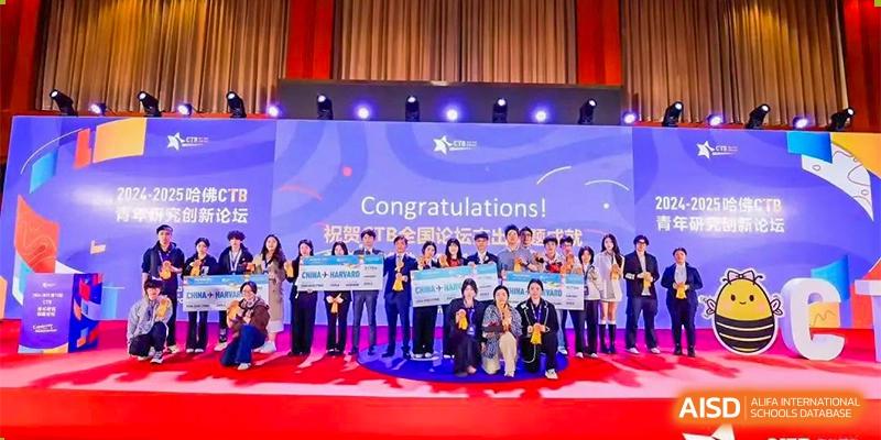 A large group of students and staff standing on stage with awards and banners during a school recognition or graduation ceremony. Canada British Colombia International Schools-Hefei.