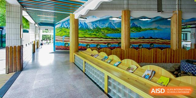 An indoor area at Wuhan Foreign Languages School International Division designed with landscape murals and student seating.