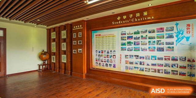 A wooden display board with photos and information on the "Students' Club" inside Wuhan Foreign Languages School International Division.