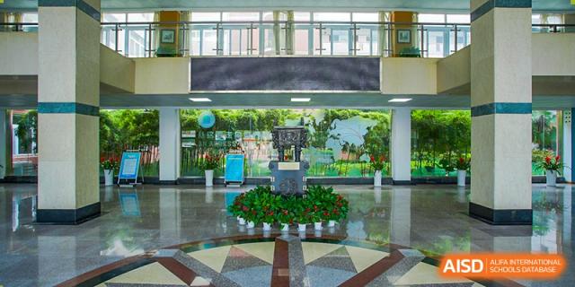 The spacious, modern school lobby or atrium with a central display and large windows at Wuhan Foreign Languages School International Division.