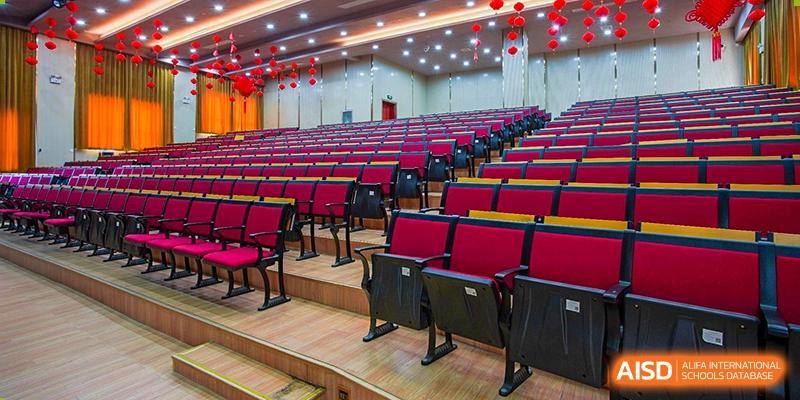 Rows of empty red and black seating in a school auditorium or lecture hall at Wuhan Foreign Languages School International Division.