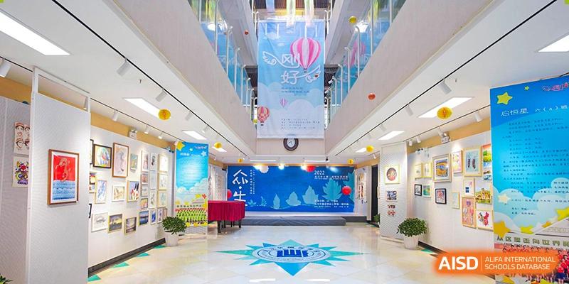 The spacious, multi-story school lobby with large banners and student artwork displays at Wuhan Foreign Languages School International Division.