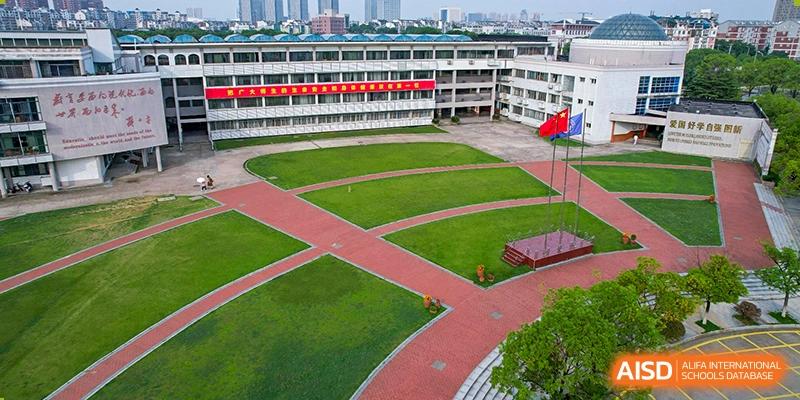 An aerial view of the school courtyard with grass fields and red walking paths at Wuhan Foreign Languages School International Division.