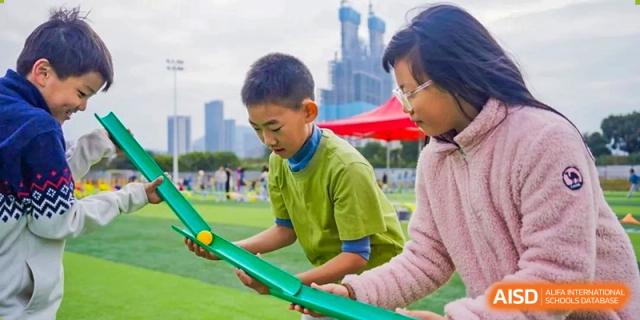 An adult and a student working together on a physics or science project outdoors at Huitong School & Studios.