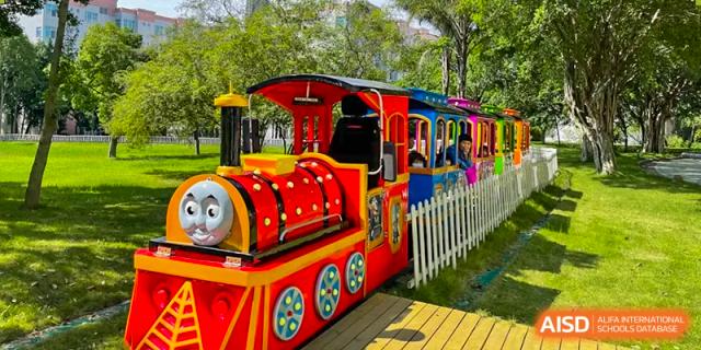A colorful miniature trackless train ride for younger students parked on a sunny day at the school. Beanstalk International Bilingual School (BIBS) - Chengdu