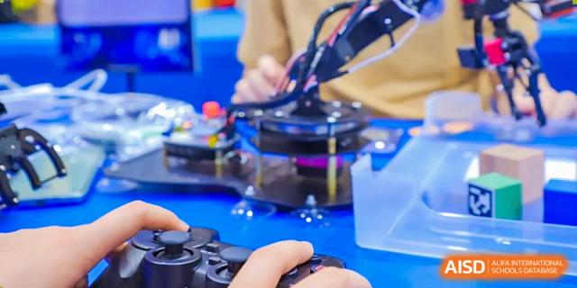 Students from Beijing Xin Fuxue International Academy use tools to work on a robotics project.