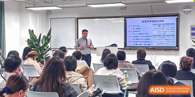 A teacher at Beijing Xin Fuxue International Academy gives a lesson to students in a modern classroom with a large screen.