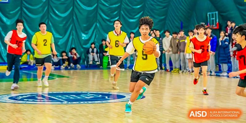 A student from Beijing Xin Fuxue International Academy dribbles a basketball down the court during a game.