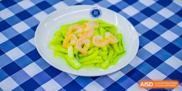 Shrimp and green vegetables are served together on a plate, a healthy option at Beijing Xin Fuxue International Academy.