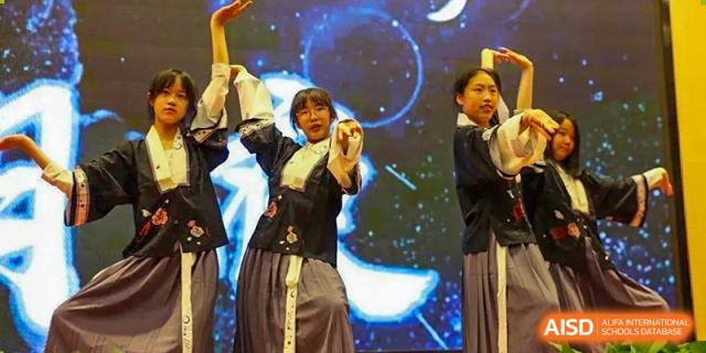 A student in traditional clothing performing on stage at SUZHOU INTERNATIONAL FOREIGN LANGUAGE SCHOOL.