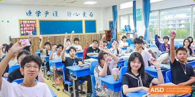 A group of students from Xi'an Jiaotong-Liverpool University Affiliated School (XJTLU-AS) raise their hands in class to answer a question.