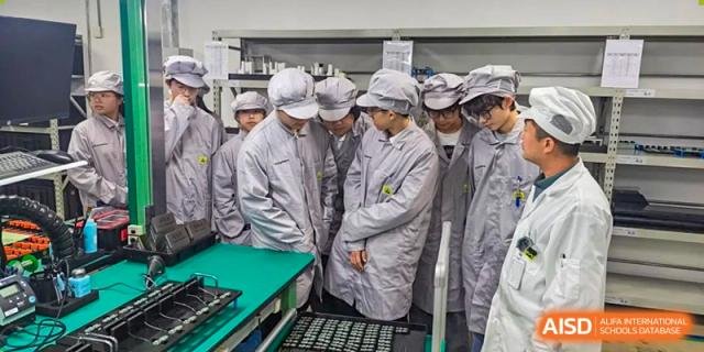Students from Xi'an Jiaotong-Liverpool University Affiliated School (XJTLU-AS) in a workshop or laboratory, wearing protective gear.
