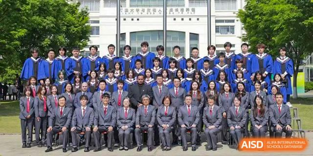A large group of students and faculty from Xi'an Jiaotong-Liverpool University Affiliated School (XJTLU-AS) are posing for a formal graduation photo.