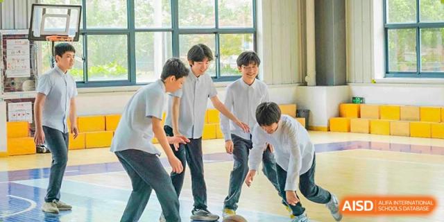 A group of male students from Xi'an Jiaotong-Liverpool University Affiliated School (XJTLU-AS) in a classroom, with one student dribbling a basketball.