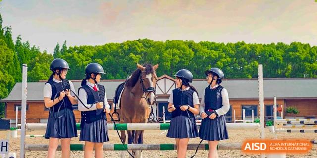 Students from Xi'an Jiaotong-Liverpool University Affiliated School (XJTLU-AS) participating in an equestrian activity with a horse.